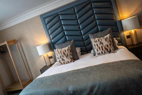 a bedroom with a large bed with two lamps at Beaufort Hotel in Inverness