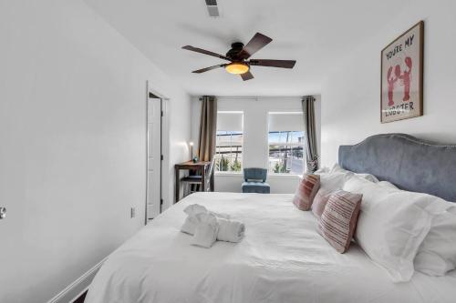 a bedroom with a white bed with a ceiling fan at Coffee | Streaming TV | Fast WIFI | Pet Friendly in Seaside Heights