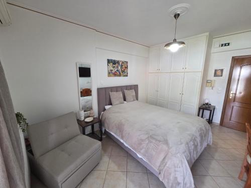 a bedroom with a bed and a couch and a chair at Lena's Nest Nafpaktos in Nafpaktos