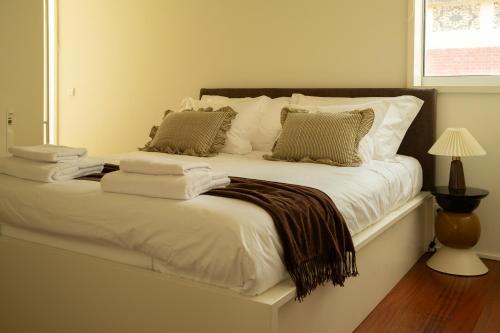 a white bed with pillows and a blanket on it at Casanova Seaside in Porto