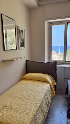 a bedroom with a bed with a yellow bedspread and a window at WELCOME - Scilla Casa Vacanze in Scilla