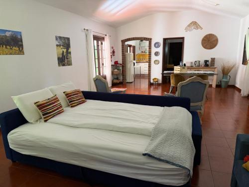 a bedroom with a bed and a living room at Quinta do Faisco in Évora