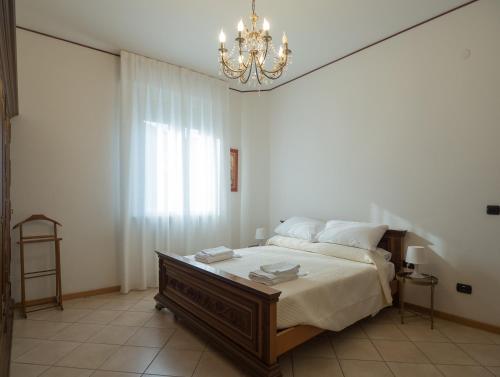 a bedroom with a large bed and a chandelier at Antonio Rooms 2 in Parma