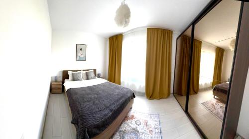 a bedroom with a bed and a large mirror at DAV apart in Otopeni