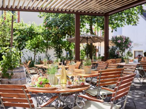 a group of tables and chairs with food on them at Hotel Zeltinger-Hof - Gasthaus des Rieslings in Zeltingen-Rachtig