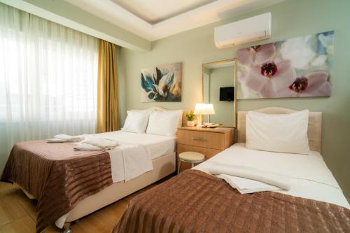 a hotel room with two beds and a mirror at Hotel Dost in Marmaris