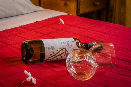 a bottle of wine and a glass on a bed at G&P Rooms Matala in Matala