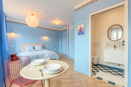 a bedroom with a bed and a table with plates on it at Le Cottage du Louvre in Lens