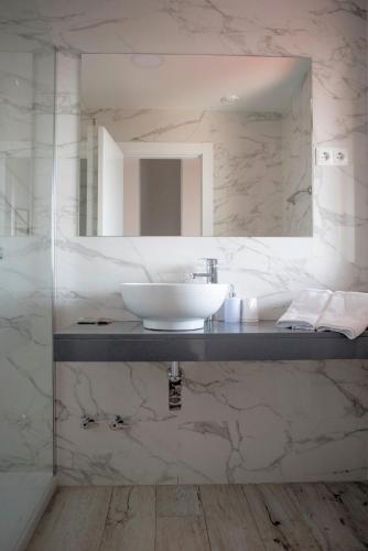 a bathroom with a sink and a mirror at Hotel Montañés in Suances