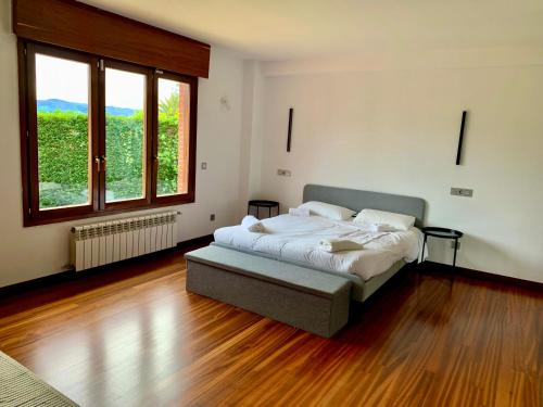 a bedroom with a bed in a room with wood floors at Ecopausa Somió - Gijón in Gijón