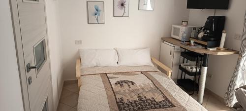 a small room with a bed and a microwave at Il Cas8tto in Pozzuoli