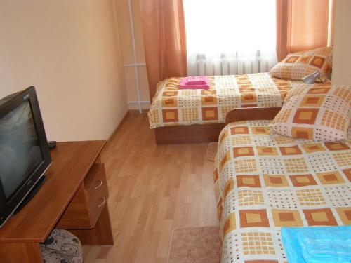 a hotel room with two beds and a flat screen tv at ABBA Hotel in Kyiv