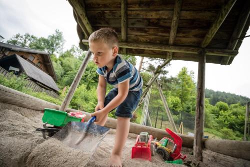 a young boy playing with toys in the sand at Gasthof zum Hammer in Göstling an der Ybbs