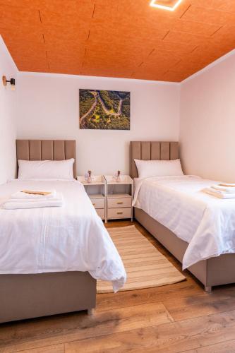 two beds in a room with white walls and wood floors at Next Lap - Rooms in Quiddelbach