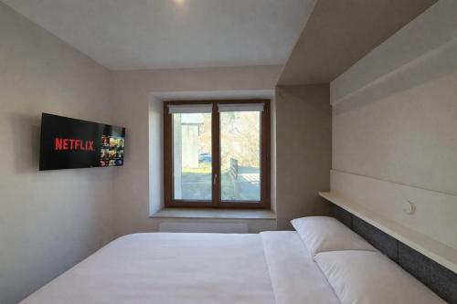 a bedroom with a large bed and a window at Studio Spa Murol Centre Relaxation in Murol