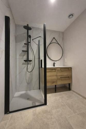 a bathroom with a shower with a mirror and a sink at Studio Spa Murol Centre Relaxation in Murol