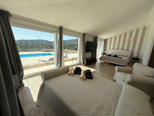 a bedroom with a bed and a view of a pool at Villa Mbita Sardegna in Brunella
