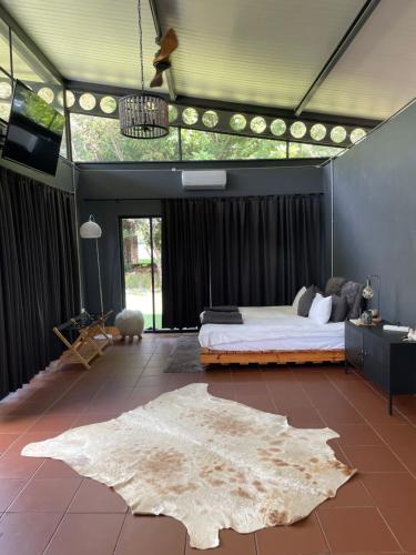 a bedroom with a large bed and a rug at Hartbeespoort Escape Hot Tub and Mountain Views in Skeerpoort