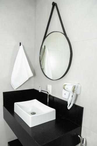 ein Badezimmer mit einem weißen Waschbecken und einem Spiegel in der Unterkunft Caza Flat Hotel in Constantina