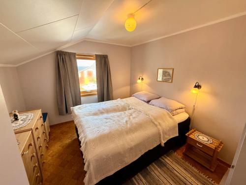 a bedroom with a large bed and a window at Cozy House by the Lake in Vestvågøya