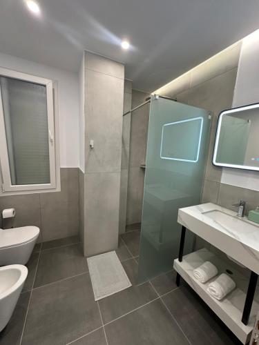 a bathroom with a shower and a sink and a toilet at Villa Billa in Tirana