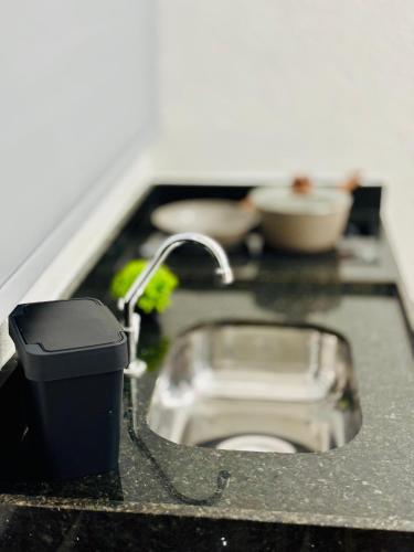 a bathroom counter with a sink and a toilet at Voer Jequitibá Hospedaria in Jequitibá