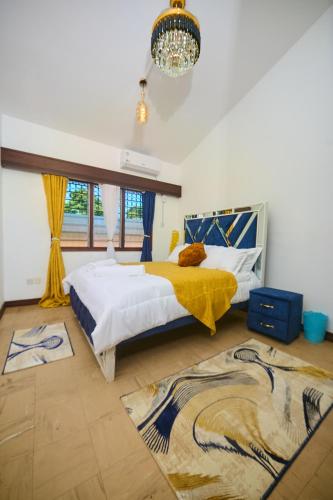 a bedroom with a bed with a yellow blanket on it at Cutie 3 br Villa Nyali in Mombasa