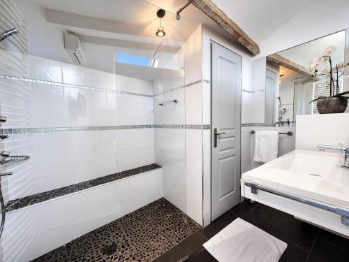 a white bathroom with a sink and a mirror at Suite Notre Dame - Appartements in Cannes