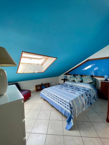 a bedroom with a bed with a blue ceiling at Orizzonte guest house in Laigueglia