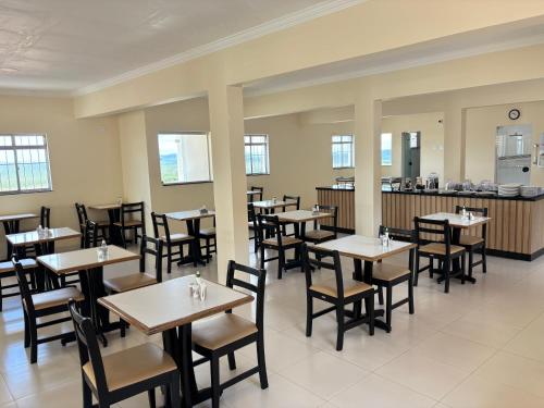 a restaurant with tables and chairs and a counter at Monte Santo palace hotel in Monte Santo