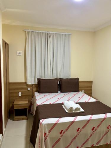 a bedroom with a large bed with a window at Monte Santo palace hotel in Monte Santo