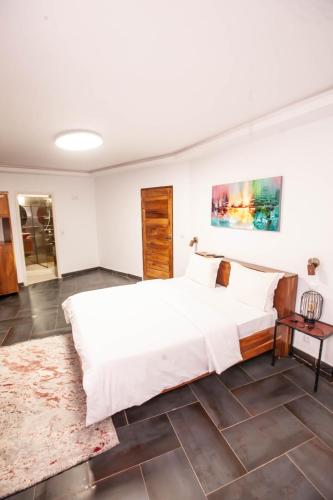 a bedroom with a large white bed and a rug at Hacienda in Saly Portudal