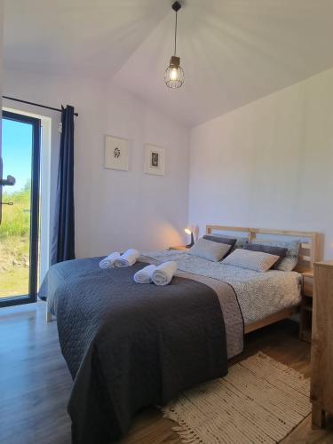 a bedroom with a bed with two towels on it at VIEW of SMEREK- domki z klimatyzacją in Smerek