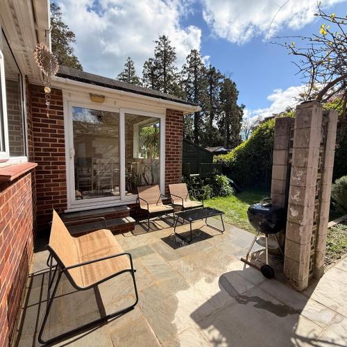 a patio with chairs and a grill in a yard at Beach Bungalow in Bournemouth