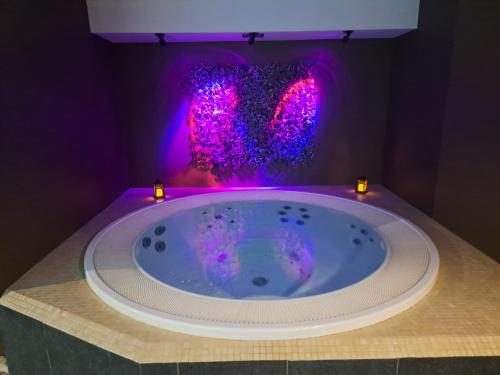 a bathroom with a jacuzzi tub with purple lights at Suites et Wellness des Champs-Elysées in Ciney