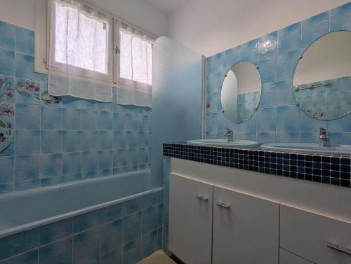 a bathroom with two sinks and a tub and two mirrors at Gite De La Meronne in Vindelle