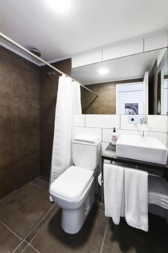a bathroom with a white toilet and a sink at Hotel Alto San Isidro in San Isidro