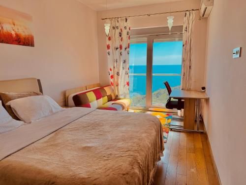 a bedroom with a bed and a desk and a window at Romantic Hillside Escape Sea View in Budva