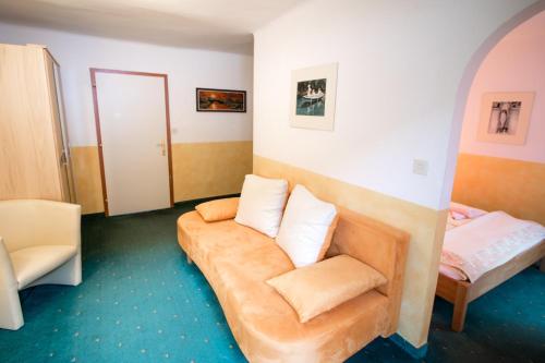 a living room with a couch and a bed at Gasthof zum Hammer in Göstling an der Ybbs