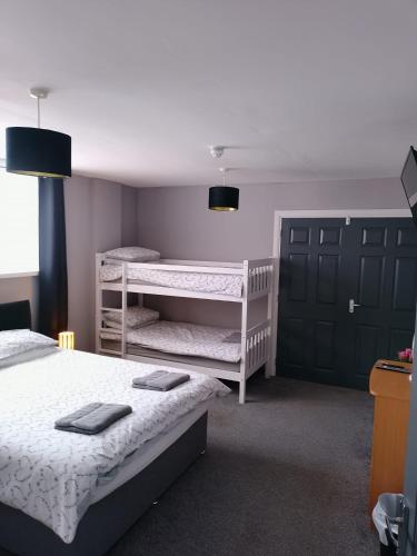 a bedroom with two beds and a bunk bed at The Hive Great Yarmouth in Great Yarmouth