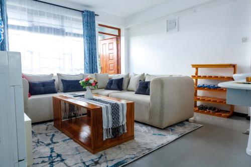 a living room with a couch and a table at Pearl Homes Nanyuki in Nanyuki