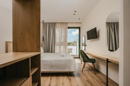 a hotel room with a bed and a desk at La Mirage Hotel in Tsilivi