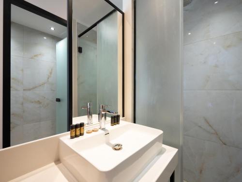 a bathroom with a white sink and a mirror at La Mirage Hotel in Tsilivi