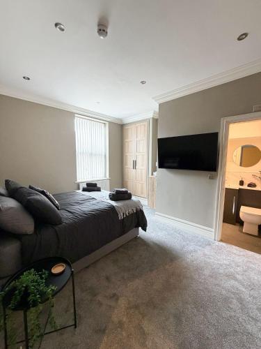 a bedroom with a bed and a flat screen tv at 4 James street in Selby