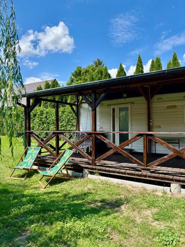 two chairs sitting on the porch of a house at Domek z widokiem na las in Nielisz