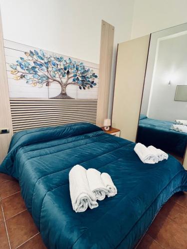 a bedroom with a blue bed with towels on it at HeraDea in Crotone
