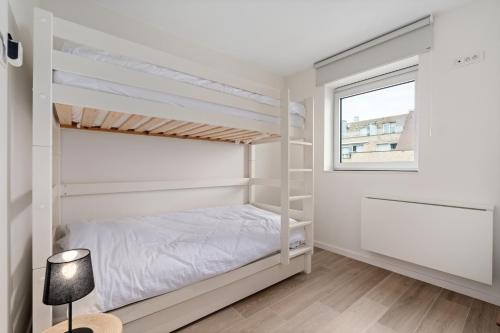 a bedroom with two bunk beds and a window at Baldus 0401 P47 in Sint-Idesbald