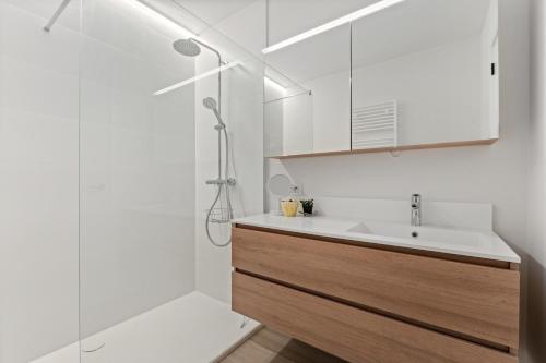 a white bathroom with a sink and a shower at Baldus 0401 P47 in Sint-Idesbald