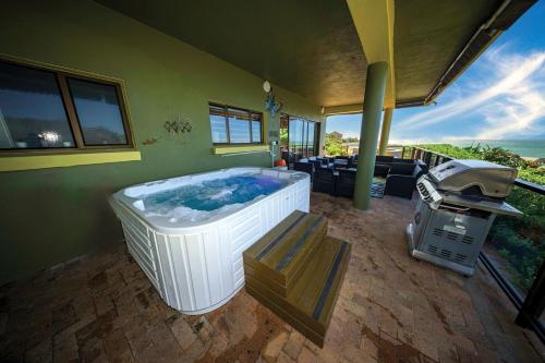 a large hot tub in a room with a grill at The Butterfly Villa in Pringle Bay