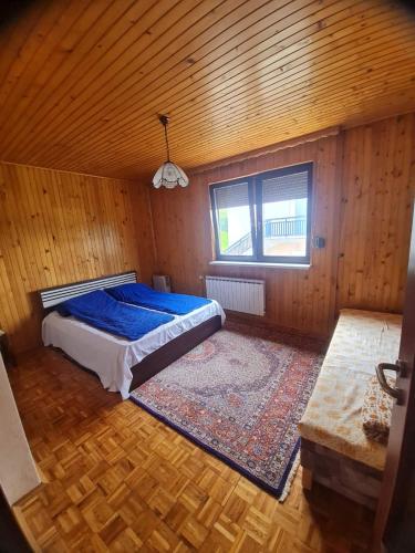 a bedroom with a bed in a wooden room at Apartmani Bistrivoda in Vogošća